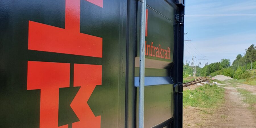 En bild på en svart container stående utomhus i solljus.